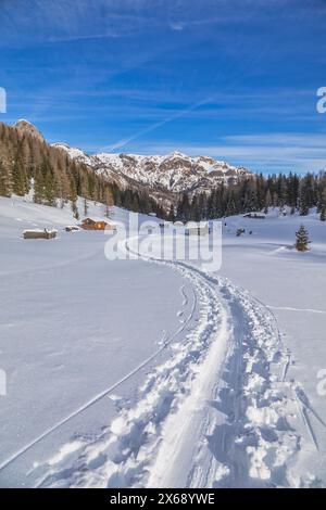 Italie, Vénétie, province de Belluno, Rocca Pietore, cabanes traditionnelles en bois à Franzei, paysage enneigé, Dolomites Banque D'Images