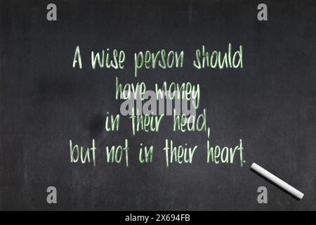 Blackboard avec une citation du XVIIIe siècle était un satiriste anglo-irlandais Jonathan Swift disant : «Une personne sage devrait avoir de l'argent dans sa tête, mais non Banque D'Images