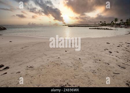 Plage de rêve des Caraïbes avec des palmiers, plage de sable blanc et turquoise, eau cristalline dans la mer. Baie peu profonde au coucher du soleil. Plage de Sainte Anne, Grande Terre, Guadeloupe, Antilles françaises Banque D'Images