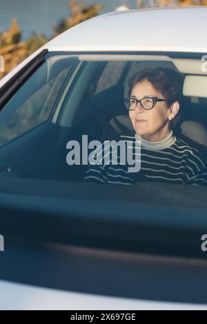 Portrait d'une femme sur le siège passager profitant de la vue sur un voyage en voiture. Banque D'Images