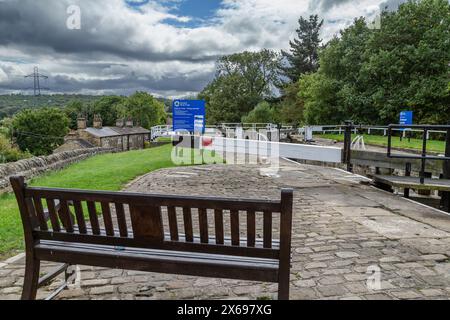 Un siège en bois donnant sur Dobson Lock (Dobson Locks) sur le Leeds Liverpool canal à Apperley Bridge, Yorkshire. Banque D'Images