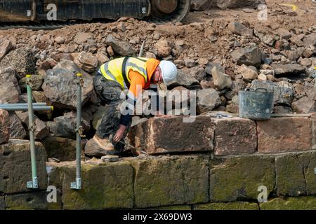 Réparation de l'ancien mur du port de North Berwick, Écosse Royaume-Uni. Le port a été endommagé lors des tempêtes hivernales de 2023. Banque D'Images