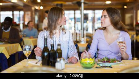Deux amies qui parlent sans souci au dîner au restaurant Banque D'Images