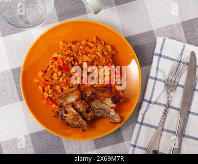 Sur une poitrine de porc grillée blanche garnie d'orge perlé. Banque D'Images