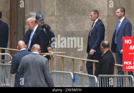 L’ancien président Donald Trump sort de la Cour pénale de Manhattan avec son fils Eric Trump (à droite) suite au témoignage du dernier témoin de l’accusation lors de la toute première affaire pénale impliquant un président des États-Unis le 13 mai 2024 à New York. Trump est accusé d’une dissimulation concernant le paiement de « Hush money » à une star de cinéma adulte Stormy Daniels. L'affaire portée par le procureur de Manhattan Alvin Bragg stipule que l'ancien avocat de Trumps Michael Cohen a payé Daniels, sur ordre de l'ancien président, 130 000 $ pour cacher l'implication personnelle de Trumps avec la star de cinéma. Th Banque D'Images