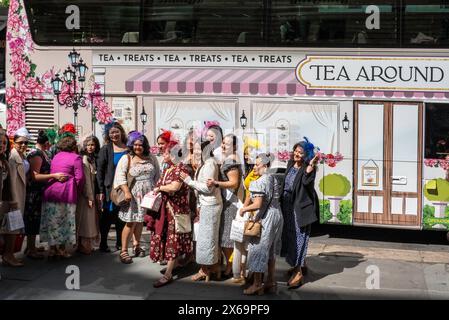 Des femmes bien habillées posent pour des photos devant le bus de fête 'tea around Town' le 42e à Midtown Manhattan par une journée ensoleillée, NYC, USA Banque D'Images