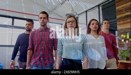 Image de plusieurs graphiques et de divers collègues confiants marchant côte à côte au bureau Banque D'Images