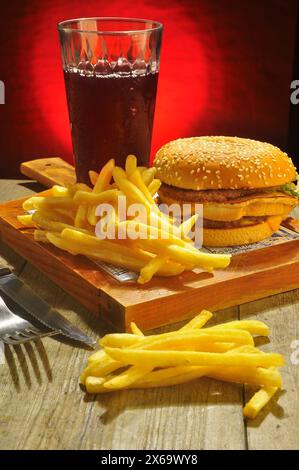 Hamburger avec frites et boisson coca cola sur dégradé rouge Banque D'Images