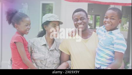 Image de lumières sur la mère soldat afro-américaine heureuse embrassant les enfants et le mari Banque D'Images