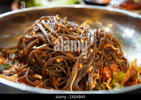 nouilles de sarrasin avec sauce épicée sur une assiette en acier inoxydable, gros plan Banque D'Images