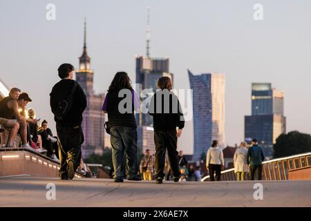 Varsovie, Pologne. 13 mai 2024. On voit des gens marcher le long du nouveau pont piétonnier et cycliste qui traverse la Vistule. Le nouveau pont piétonnier et cyclable sur la Vistule mesure 452 mètres de long et relie le centre-ville au quartier de Praga. Il a été ouvert le 28 mars 2024 et est devenu très populaire parmi les résidents de la ville et les touristes. Depuis le pont, les piétons et les cyclistes peuvent profiter de la vue sur la Vistule et Varsovie, y compris le centre historique - un site classé au patrimoine mondial de l'UNESCO. (Photo de Volha Shukaila/SOPA images/Sipa USA) crédit : Sipa USA/Alamy Live News Banque D'Images