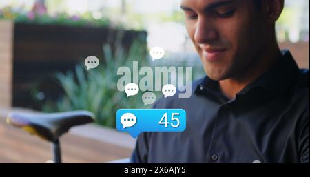 Image de plusieurs icônes de médias sociaux au-dessus de l'homme caucasien utilisant smartwatch à l'extérieur Banque D'Images