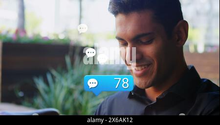 Image de plusieurs icônes de médias sociaux au-dessus de l'homme caucasien utilisant smartwatch à l'extérieur Banque D'Images