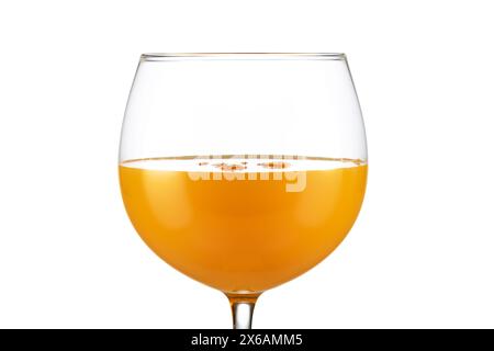 Extrême gros plan de jus d'orange dans un verre de ballon isolé sur fond blanc. Banque D'Images