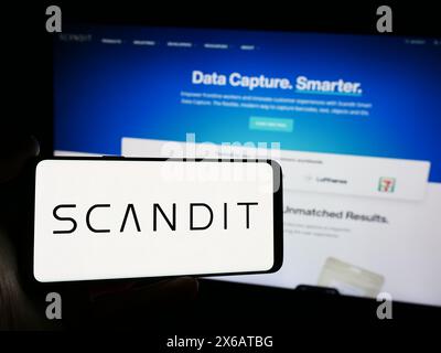 Personne tenant le téléphone portable avec le logo de la société technologique suisse Scandit AG devant la page Web de l'entreprise. Concentrez-vous sur l'affichage du téléphone. Banque D'Images