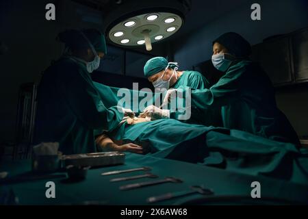 Équipe médicale effectuant la chirurgie en salle d'opération. Banque D'Images