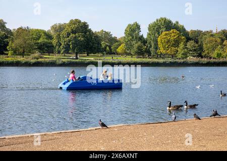 Hyde Park Londres, jeunes parents avec enfant en pédalo sur la Serpentine, pendant le temps chaud de septembre, Londres, Angleterre, Royaume-Uni, 2023 Banque D'Images