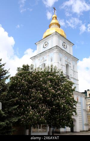 Non exclusif : KIEV, UKRAINE - 11 MAI 2024 - Un châtaignier en fleurs est représenté par le clocher du monastère St Michael&#x92;s à dôme doré, Banque D'Images