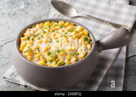 Maïs crémeux avec crème, lait et parmesan râpé gros plan sur le bol sur la table. Horizontal Banque D'Images