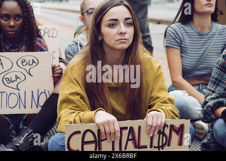 Représentation de jeunes militants participant à une manifestation anticapitaliste, tenant des pancartes et montrant de la détermination, manifestation de rue pour la société Banque D'Images