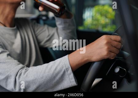 C'est une chose dangereuse à faire. Boire de la bière en conduisant est à la fois illégal et dangereux. Banque D'Images