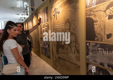 Athènes, Grèce. 11 mai 2024. Les visiteurs voient l'introduction de l'art des grottes chinoises au Zappeion Hall à Athènes, Grèce, le 11 mai 2024. L'exposition touristique internationale de la restauration numérique des grottes de Tianlong s'est tenue à Athènes et a attiré de nombreux visiteurs. Crédit : Marios Lolos/Xinhua/Alamy Live News Banque D'Images