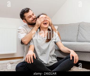 Faire une surprise. Couple amoureux à la maison. Banque D'Images