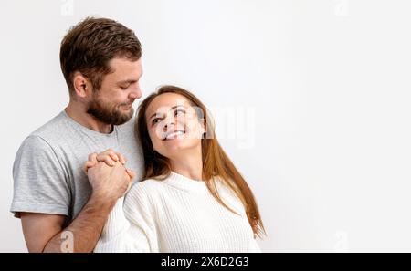 Heureux aimant couple jeune adulte embrassant sur fond blanc. Couple hétérosexuel amoureux. Banque D'Images