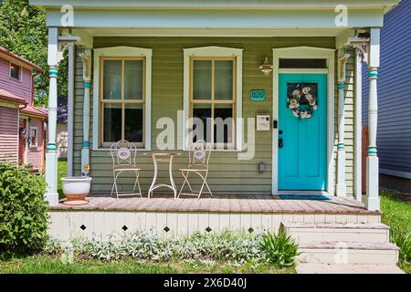 Charmante maison verte pastel avec porche confortable et porte Turquoise, Amérique de banlieue Banque D'Images