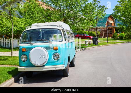 Vintage Blue Van et voiture moderne dans Sunny Suburban Street Banque D'Images