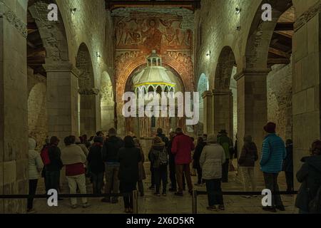 Les touristes visitent l'abbaye de San Pietro ad Oratorium, admirent le ciborium du 13ème siècle et le cycle de fresques dans l'abside. Capestrano, Abruzzes Banque D'Images