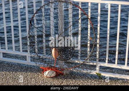 Un filet à crabe repose contre la balustrade métallique sur Mount Pleasant Pier qui se trouve au-dessus du port de Charleston en Caroline du Sud, aux États-Unis Banque D'Images
