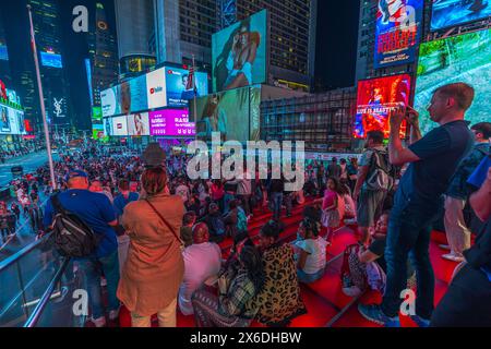 Superbe panorama nocturne depuis les escaliers rouges, offrant un aperçu de Times Square, avec des piétons se promenant le long de Broadway à Manhattan. New York. Banque D'Images