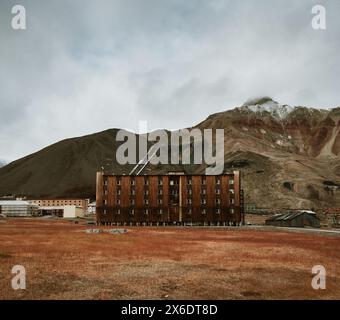 Grand bâtiment soviétique abandonné dans le paysage sombre de Pyramiden, Svalbard Banque D'Images