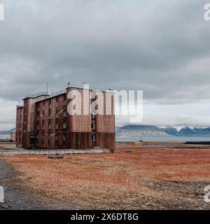 Grand bâtiment soviétique abandonné dans le paysage sombre de Pyramiden, Svalbard Banque D'Images