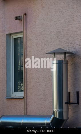 Tuyaux de ventilation en métal sur le mur extérieur d'un bâtiment industriel beige sur fond. Banque D'Images