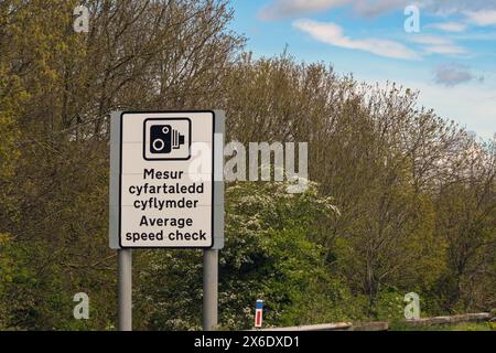 Symbole de radar sur un panneau bilingue indiquant le début d'une zone de contrôle de vitesse moyenne sur une autoroute au pays de Galles Banque D'Images
