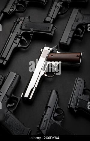 Une variété de pistolets sur un fond sombre. Armement pour l'armée et la police. Arme à canon court. Banque D'Images