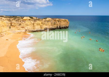 Vue sur les falaises et les canoës sur l'océan, plage Praia da Ponta Pequena près d'Albufeira, Portugal Banque D'Images