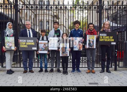 Londres, Royaume-Uni. 14 mai 2024. Amnesty International des Palestiniens britanniques et britanniques ayant de la famille à Gaza, dont l'écrivain et réalisateur AHMED MASOUD et le militant WAFAA SHAMALLAKH, se tiennent devant Downing Street avec des photos des membres de leur famille, appelant Rishi Sunak à mettre fin aux ventes d'armes britanniques à Israël alors que l'armée israélienne attaque Rafah. La manifestation a lieu à la veille du jour de la Nakba. Crédit : Vuk Valcic/Alamy Live News Banque D'Images