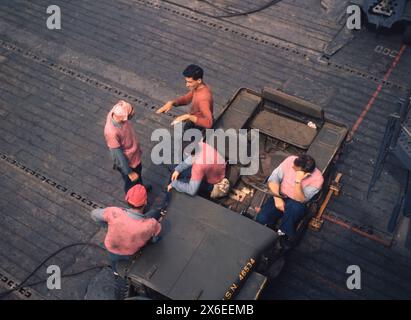 L'équipage de l'essence se détend autour de Jeep sur l'USS Lexington (CVA-16) lors de la Lull in Operations, novembre 1943 Banque D'Images