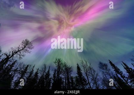 Les aurores boréales éclatent au-dessus d'un lac dans le Minnesota dans un ciel sombre au-dessus de l'arc-en-ciel brillant de lumière aurore Banque D'Images