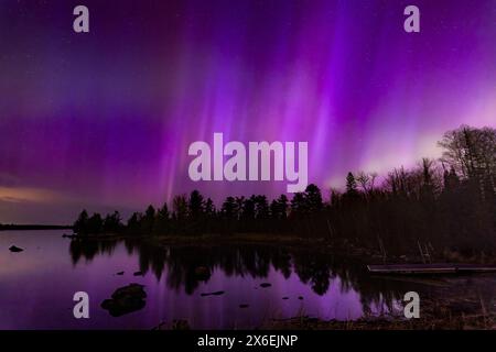 L'aurore magenta dans le ciel nocturne s'élève au-dessus du lac Boulder dans le nord du Minnesota Banque D'Images