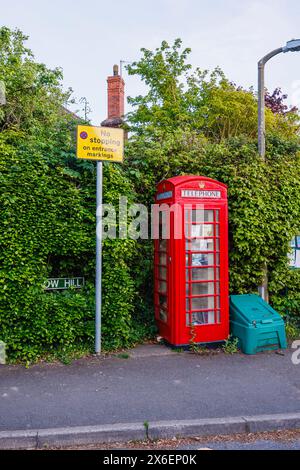 Une boîte téléphonique rouge traditionnelle désutilisée pour la téléphonie maintenant utilisée comme bibliothèque à Callow End, un village du district de Malvern Hills, Worcestershire, en Angleterre Banque D'Images