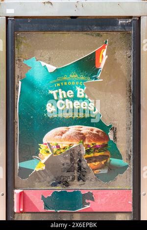 Affiche déchirée et déchirée faisant la publicité d'une marque de cheeseburger Banque D'Images