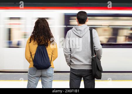 Couple attendant le train dans la plate-forme de la station de métro.Concept de transport public. Banque D'Images