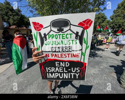 Palo Alto, Californie, États-Unis 12 mai 2024. Une manifestante pro-palestinienne à l'université de Stanford à l'occasion de la fête de l'indépendance d'Israël et de la fête des mères tente agressivement d'empêcher la caméra des photojournalistes de photographier les manifestants en la suivant avec une pancarte indiquant : « protéger la presse journaliste en Palestine : mettre fin à l'impunité Israël-États-Unis ». Des drapeaux palestiniens sont visibles en arrière-plan. (Crédit image : © Amy Katz/ZUMA Press Wire) USAGE ÉDITORIAL SEULEMENT! Non destiné à UN USAGE commercial ! Banque D'Images