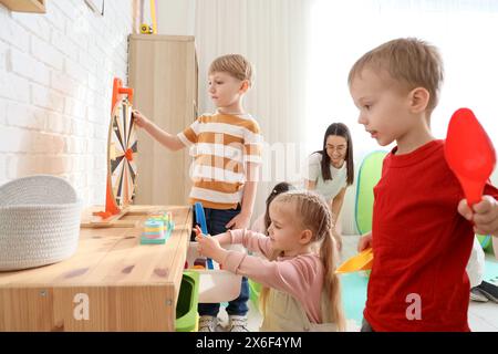 Petits enfants avec professeur de maternelle jouant à la maternelle Banque D'Images