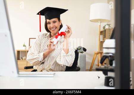 Diplômée en fauteuil roulant avec un diplôme de chat vidéo à la maison Banque D'Images