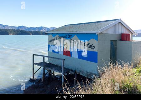 Murale de bienvenue sur le côté du hangar à bateaux, Marine Drive, Charteris Bay, Lyttelton Harbour, Banks Peninsula, Canterbury, Nouvelle-Zélande Banque D'Images